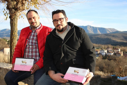 Los hermanos Marcos y Daniel López sentados frente a su obrador de pastelería con el paisaje de la sierra de Gredos a su espalda.-