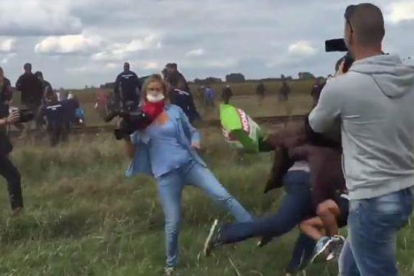 Fotograma en el que se puede ver a la reportera zancadilleando a un refugiado con un niño en brazos.-YOUTUBE