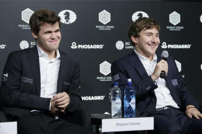 El noruego Carlsen (izquierda) sonríe mientras el derrotado ajedrecista ruso Karjakin habla en la rueda de prensa posterior a la partida definitiva.-JUSTIN LANE / EFE