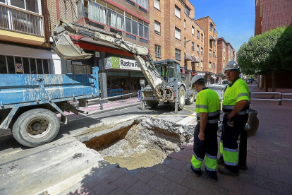 Dos operarios trabajan en la reparación de la fuga de agua.-J.M. LOSTAU