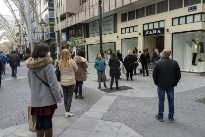 Un grupo de personas espera para entrar a una de las tiendas de la calle Santiago de Valladolid. PHOTOGENIC / PABLO REQUEJO
