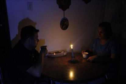 Una pareja toma un café en una establecimiento público a la luz de las velas.-EFE