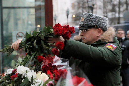 Un soldado ruso deposita flores en un pequeño altar montado ante la sede del Alexandrov Ensemble (El coro del Ejército Rojo) en Moscú (Rusia) ayer, 26 de diciembre de 2016.-EFE