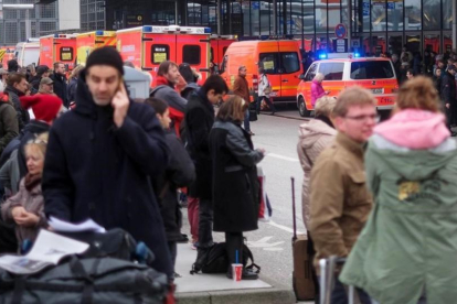 Bomberos y pasajeros evacuados del aeropuerto de Hamburgo.-AXEL HEIMKEN