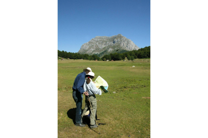 Una pareja de senderistas franceses observa la montaña Peña Santa de Castilla en la majada de Vegabaño-Ical