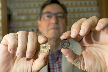 El experto numismático Javier Santos con la moneda buena (d)y la del error, a la izquierda, en la que falta la Y entre Castilla y León.-PABLO REQUEJO (PHOTOGENIC)