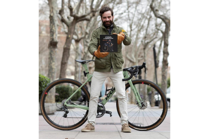 Sergio Monge posa con su libro, delante de su inseparable bicicleta.-EL MUNDO