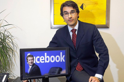 Luis Gervás, en su despacho de Valladolid, ante una imagen del creador de Facebook, Mark Zuckerberg.-J.M. LOSTAU