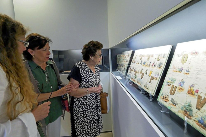 Tres visitantes observan un grupo de paneles que forma parte de la exposición inaugurada ayer en Urueña.-ICAL