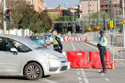 Dos policías municipales controlan el tráfico en la calle Estación, recién cortada. J. M. LOSTAU