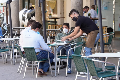 Un camarero atiende a los clientes en una terraza del centro de Valladolid. J.M. LOSTAU