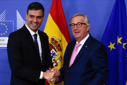 Sánchez y Juncker se saliudan antes de la reunión que han mantenido previa a la cumbre de la UE.-/ ARIS OIKONOMOU (AFP)