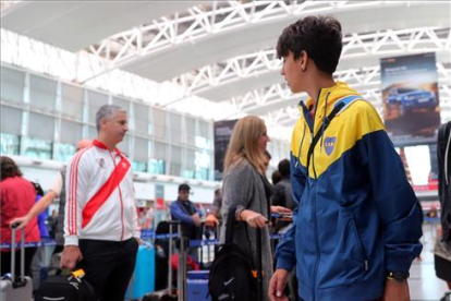 Un seguidor de River y otro de Boca, en el aeropuerto de Ezeiza, en Buenos Aires, ayer jueves.-MARCOS BRINDICCI