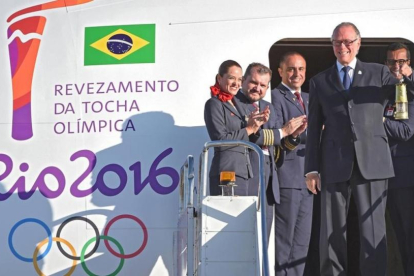El presidente del Comite Olímpico Brasileño, Carlos Arthur Nuzman, transporta la linterna con el fuego olímpico a su llegada a Brasilia.-AFP / EVARISTO SA