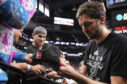 Pau Gasol firma autógrafos antes de su partido contra los Bulls.-EFE / WILLIAM J. ABATE