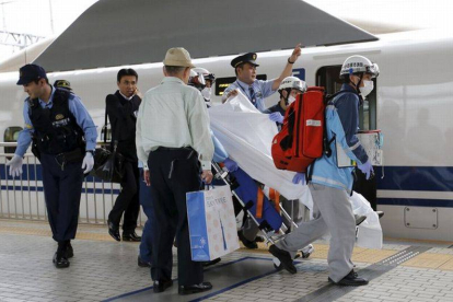 Un pasajero herido al suicidarse un individuo en un tren bala japonés es trasladado por los equipos de emergencia.-Foto: REUTERS / TORU HANAI