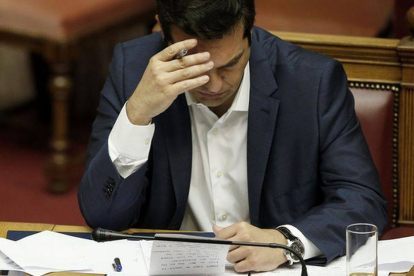 El primer ministro griego Alexis Tsipras repasa unas notas en el Parlamento.-Foto: AP