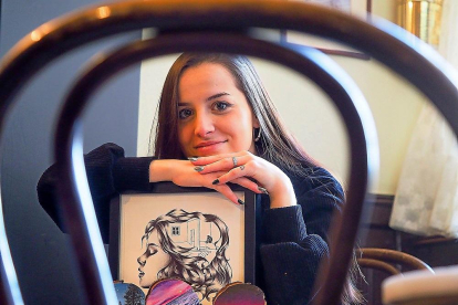 Alba González Cantalapiedra, ilustradora y diseñadora gráfica, en el café Minuto con varias de sus obras.-PABLO REQUEJO / PHOTOGENIC
