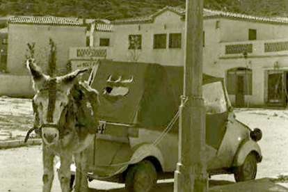 Un pollino junto a un vehículo de la época en el barrio Girón en la década de los 60. ARCHIVO MUNICIPAL