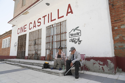Dos vecinos conversan en la fachada del Cine Castilla. J. M. LOSTAU
