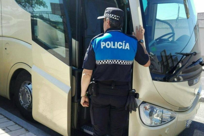 Un agente se dispone a hacer el seguimiento a un vehículo de transporte escolar.-POLICIA MUNICIPAL