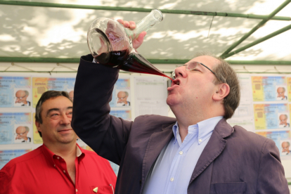 l candidato del PP a la Presidencia de la Junta de Castilla y León, Juan Vicente Herrera bebe de un porrón en el expositor de Asaja-ICAL