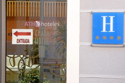 Puerta de entrada del ‘Enara’, con el nombre y logotipo de la nueva cadena ATHque explota el hotel.-J. M. LOSTAU