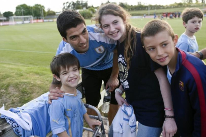 Luis Suárez posa con una jóvenes aficionados tras su primer entrenamiento con la selección uruguaya.-AP / MATILDE CAMPODONICO
