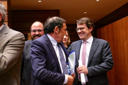 Alfonso Fernández Mañueco saluda al consejero de Sanidad, Antonio Sáez, al comienzo del Pleno de las Cortes-ICAL