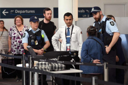 La policía realiza un control de pasajeros en el aeropuerto de Sídney.-WILLIAM WEST (AFP)