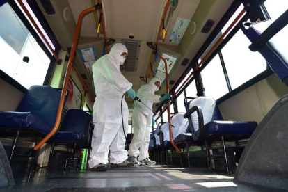 Sanitarios surcoreanos desinfectan un autobús ante la amenaza del virus MERS.-Foto:  AFP / JUNG YEON-JE