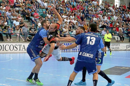 Adrián Fernández se lanza contra los jugadores de Cangas para intentar lanzar a portería.-PHOTO-DEPORTE