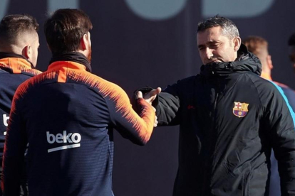 Messi y Valverde se saludan en el inicio del entrenamiento.-ALEJANDRO GARCÍA