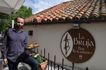 El hostelero Víctor Gómez, junto al hotel y restaurante que regenta junto a la muralla de Ávila, con uno de los platos de su carta-ARGICOMUNICACIÓN