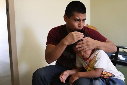 Un inmigrante centroamericano abraza a su hijo después de que lograran reunirse en El Paso, Texas.-AFP / JOE RAEDLE