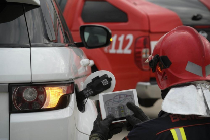 Un bombero lee un código QR para extraer toda la información del coche y de los pasajeros.-ENRIQUE CARRASCAL