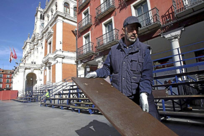 Un operario retira las gradas de Semana Santa en la Plaza Mayor-Ical