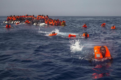 Un grupo de emigrantes y refugiados africanos intentan alcanzar a nado el barco de la oenegé Proactiva Open Arms el pasado 23 de julio.-AP / SANTI PALACIOS