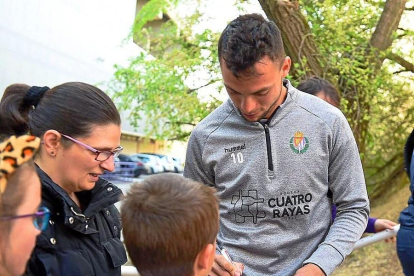 Óscar Plano firma un autógrafo a un niño tras el entrenamiento del Real Valladolid.-IÑAKI SOLA / REAL VALLADOLID