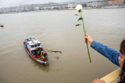 Una mujer lanza una rosa al Danubio en Budapest (Hungría).-BALAZS MOHAI (EFE)