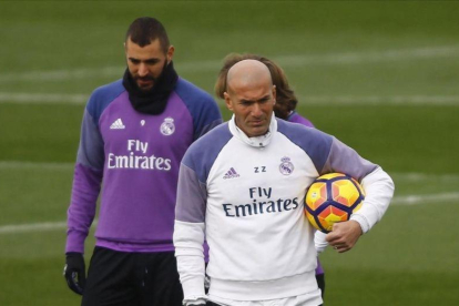 Zinedine Zidane y Karim Benzema, durante el entrenamiento de este viernes en la ciudad deportiva de Valdebebas.-AGUSTIN CATALAN