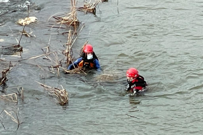 Los bomberos durante el rescate del cadáver en el Duero en Tordesillas. E. M.