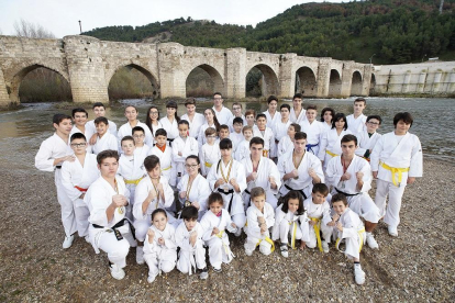 Los karatekas del ShinGiTai posan con sus karateguis frente al puente de Cabezón.-J.M. LOSTAU