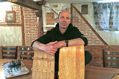 José Ángel Bravo, el ‘sortija’, en su taller de Cantalejo, con réplicas de trillos en miniatura que él mismo elabora de forma artesanal.-ARGICOMUNICACIÓN