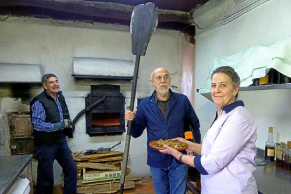 El artista Carlos León, entre Esperanza Moreno y su marido, Juan Sanz, en el horno de asar Don Juan, en Adrada de Pirón.-T. S. T.