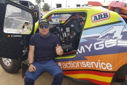 Roberto Carranza posa junto al coche en el que participará desde hoy en el Rally Dakar en Arabia Saudí.-E. M.