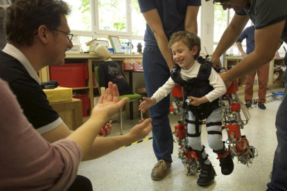 El pequeño Álvaro vestido con el exoesqueleto se lanza hacia su padre en una de las pruebas del dispositivo biónico, que le permite ponerse en pie y caminar.-CSIC