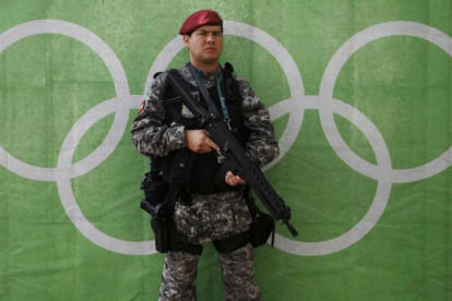 Un policía bien armado hace guardia delante de los aros olímpicos.-REUTERS / STEFAN WERMUTH