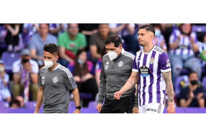 Javi Sánchez abandona lesionado el campo, acompañado por el doctor López Moreno y el ‘fisio’Gonzalo Guijarro. R. VALLADOLID