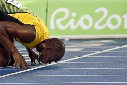 Bolt besa la pista del Estadio Olímpico tras ganar el 200.-EFE / YOAN VALAT